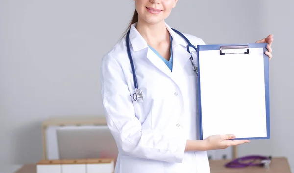 Dottoressa sorridente con una cartella in uniforme in piedi. Sorridente medico femminile — Foto Stock