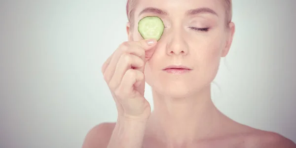 Young beautiful woman with cucumber slices on white background. — Stock Photo, Image