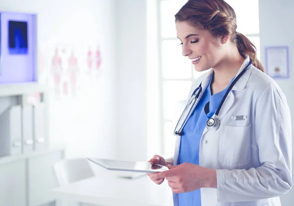 beautiful female healthcare worker using tablet computer in hospital