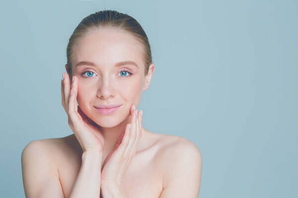 Portrait of beautiful woman with natural make up touching her face.