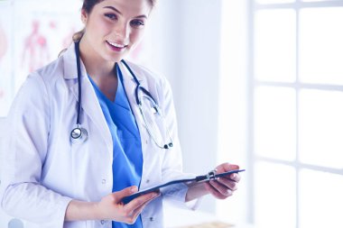 Üniformalı bir dosyayla gülümseyen kadın doktor