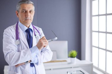 Parlak ofisinde gülümseyen bir doktorun portresi.