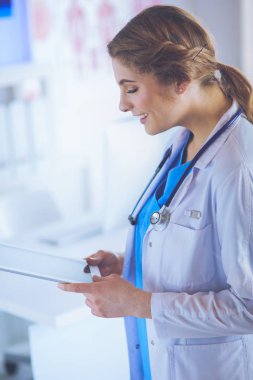 Hastane lobisinde tablet bilgisayar kullanan kadın doktor.