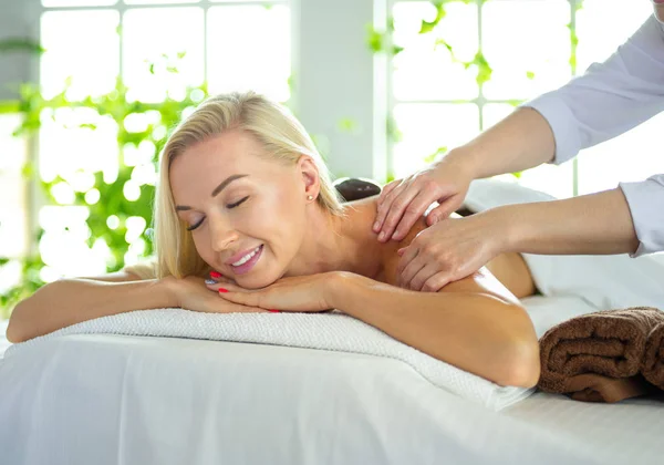 Ung kvinna njuter av massage i spa salong — Stockfoto