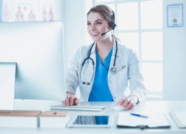 Kliniği Resepsiyon masasında çalışan genç pratisyen doktor o telefon görüþmesi ve randevuları zamanlama