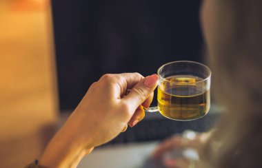 Kredi kartı tutan ve dizüstü bilgisayar kullanan genç bir kadın. Çevrimiçi alışveriş kavramı