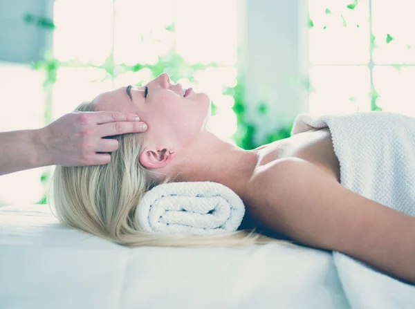 Giovane donna che si gode un massaggio nel salone spa — Foto Stock