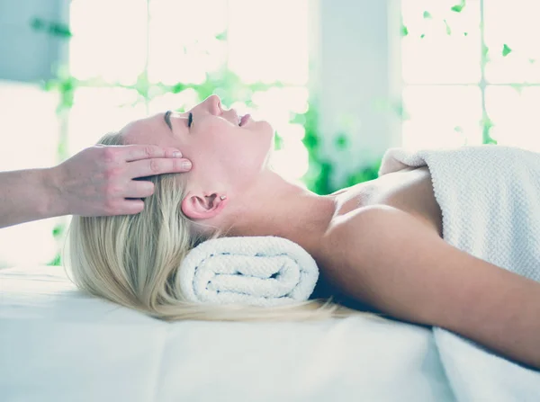 Mujer joven disfrutando de masajes en el salón de spa — Foto de Stock