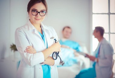 Kadın doktor hastanede steteskopla dikiliyor.