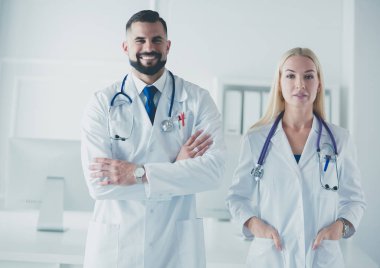 Bir doktor ekibi, kadın ve erkek, danışma odasında.