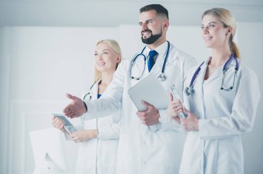Meslektaşlarının önünde el sıkışan bir erkek doktor.