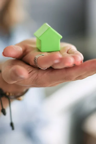 Modelo de casa en la mano de una pareja, de pie en un nuevo hogar. Casa modelo . —  Fotos de Stock