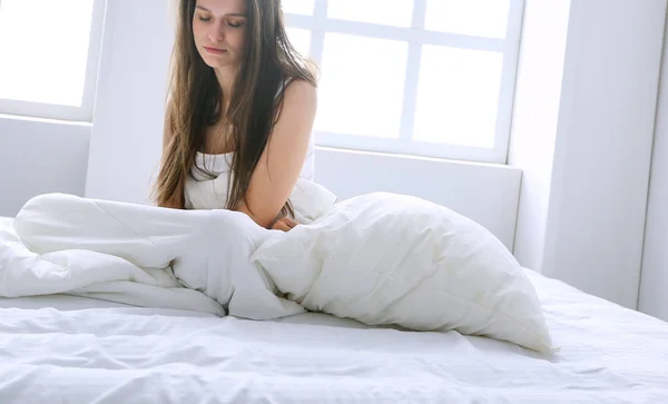 Молодая женщина чувствует боль в постели . — стоковое фото