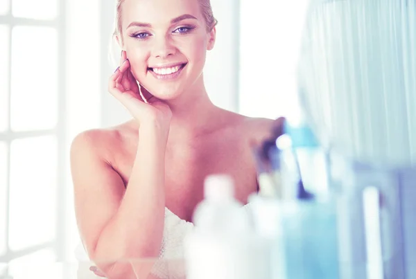 Giovane donna in accappatoio guardando nello specchio del bagno — Foto Stock