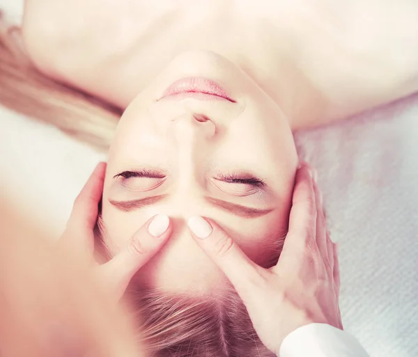 Giovane donna sdraiata su un tavolo da massaggio, rilassante con gli occhi chiusi. Una donna. Salone termale — Foto Stock