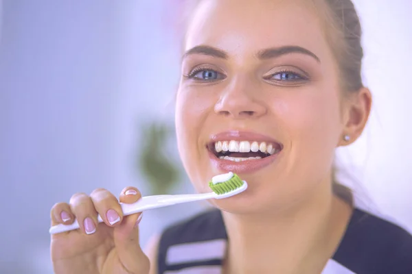 Joven chica bonita manteniendo la higiene bucal con cepillo de dientes . — Foto de Stock