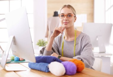 Moda tasarımcısı stüdyoda tablet bilgisayar kullanıyor.