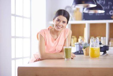 Mutfakta masada oturan genç bir kadın.