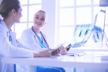 Hastanede bilgisayarla çalışan iki genç bayan doktor..