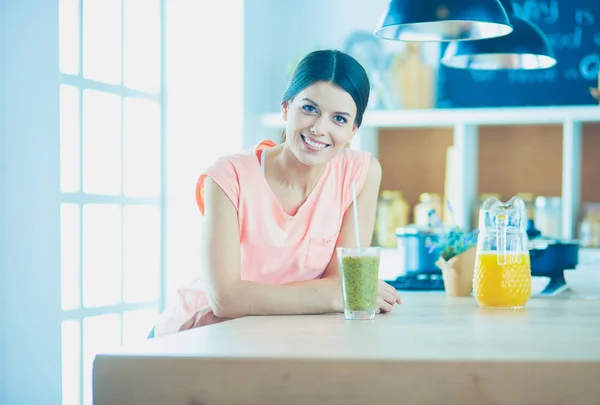 Jonge vrouw zit een tafel in de keuken — Stockfoto