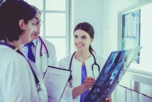 Médecins souriants discutant du diagnostic des patients regardant les rayons X dans un hôpital — Photo