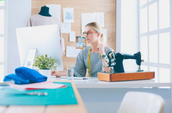 Mooi jong meisje in een fabriek met een naaimachine aan de tafel — Stockfoto