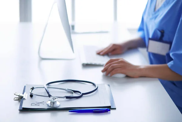 Женщина-врач сидит за столом и работает с ноутбуком в больнице — стоковое фото