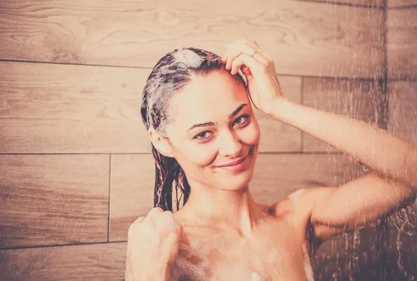 Junge schöne Frau unter der Dusche im Badezimmer. — Stockfoto