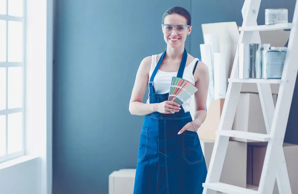 Jovem segurando uma amostra de cor com uma pintura de pintor  . — Fotografia de Stock