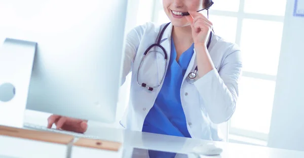 Young practitioner doctor working at the clinic reception desk, she is answering phone calls and scheduling appointments — Stock Photo, Image