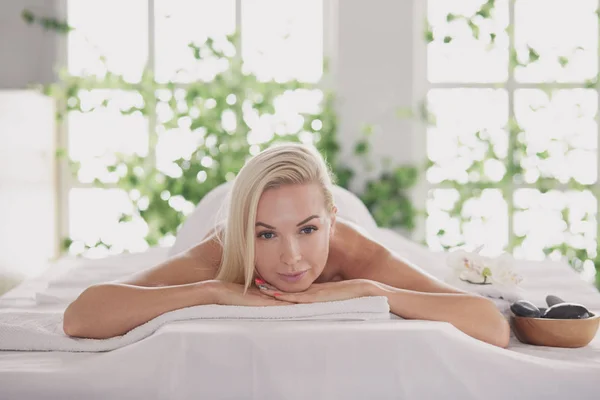 Mujer joven disfrutando de masajes en el salón de spa. — Foto de Stock