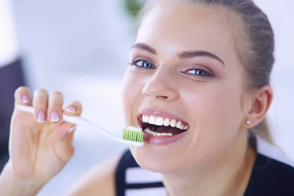 Joven chica bonita manteniendo la higiene bucal con cepillo de dientes . — Foto de Stock