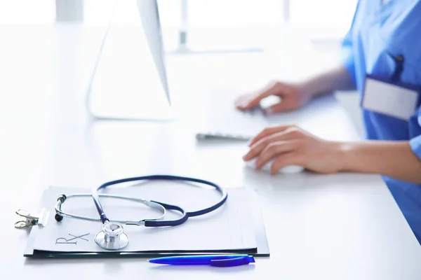 Ärztin sitzt am Schreibtisch und arbeitet im Krankenhaus an einem Laptop — Stockfoto