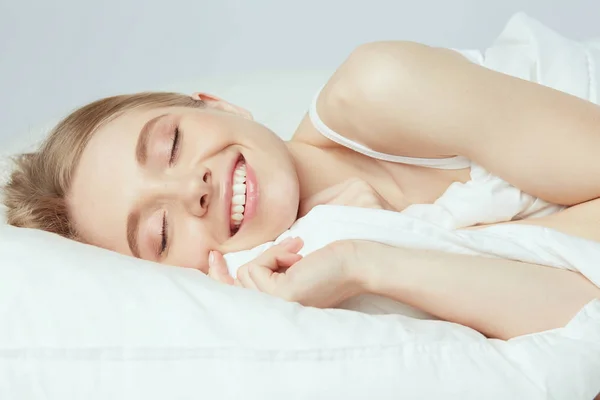 Photo of sleeping young woman lying in bed with eyes closed — Stock Photo, Image