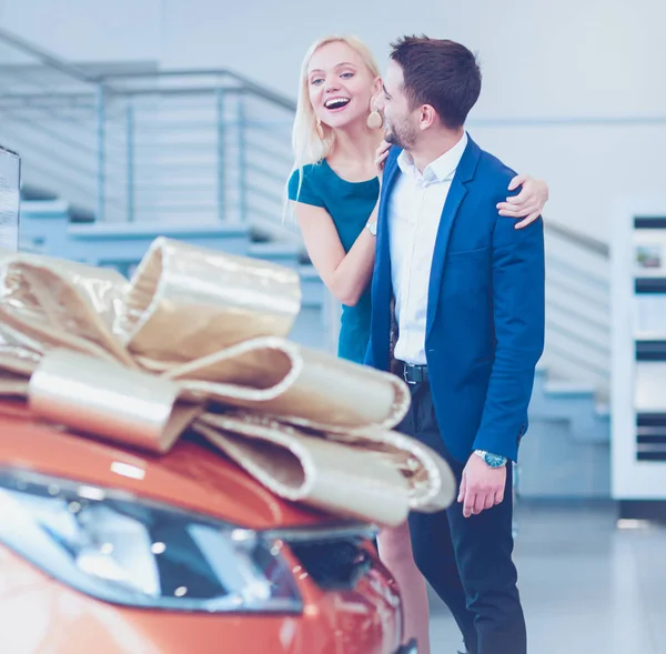 Een man maakt een geschenk - een auto aan zijn vrouw. Ze is hier verbaasd over. Ze zijn erg blij over — Stockfoto