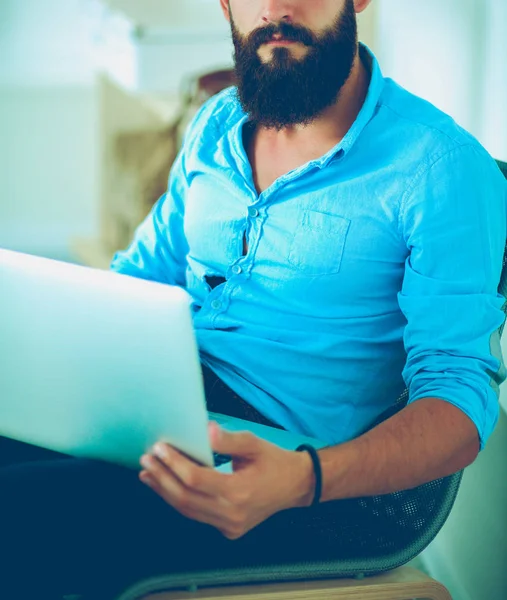 Young businessman sitting on chair in office — Stock Photo, Image