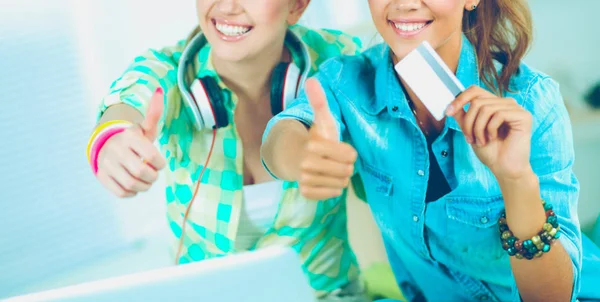 Two young women sitting with laptop and credit cart at home — Stock Photo, Image