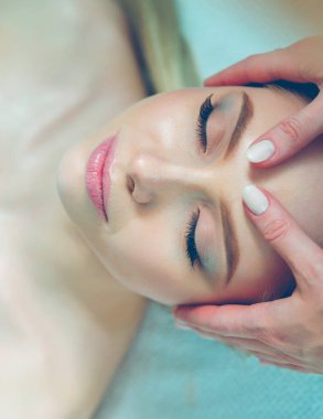 Masaj masasında uzanmış gözleri kapalı rahatlayan genç bir kadın. - Kadın. Spa salonu