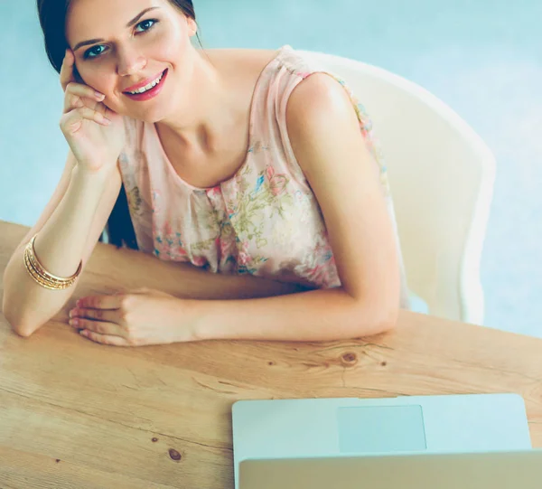 Привлекательная деловая женщина, сидящая на столе в офисе — стоковое фото