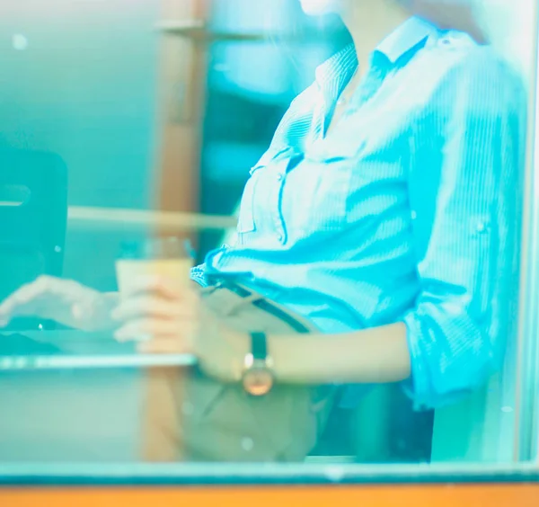 Junge Frau am Bürotisch mit Laptop, Blick durchs Fenster. Junge Frau — Stockfoto