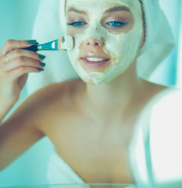 Una foto de una mujer joven aplicando polvo facial en el baño — Foto de Stock