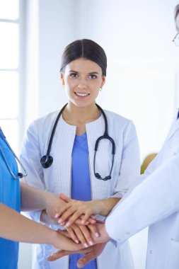 Bir grup doktor ellerini birleştiriyor. Yakın plan.