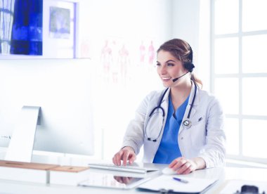 Kliniği Resepsiyon masasında çalışan genç pratisyen doktor o telefon görüþmesi ve randevuları zamanlama