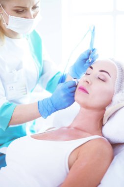 Kaşlar için kalıcı makyaj. Güzellik salonunda kalın kaşlı güzel bir kadın..