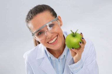 Diş hekimi kadın elinde yeşil elma ve diş fırçası tutuyor. Dişçi doktorlar. Kadın doktorlar