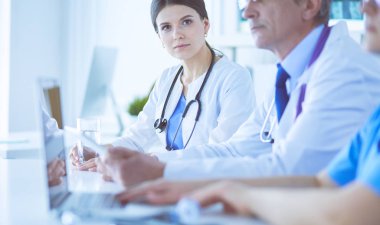 Doktorlar hastane konferans odasında birbirlerine danışıyorlar.