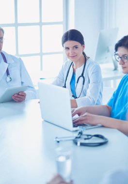 Ciddi bir tıbbi ekip hastaları parlak bir ofiste tartışıyor.