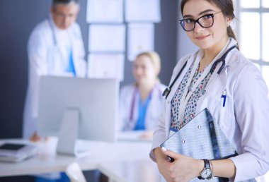 Kadın doktor hastanede steteskopla dikiliyor.