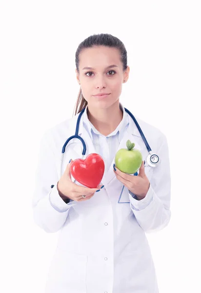 Bella sorridente medico femminile con cuore rosso e mela verde. Donna medico — Foto Stock