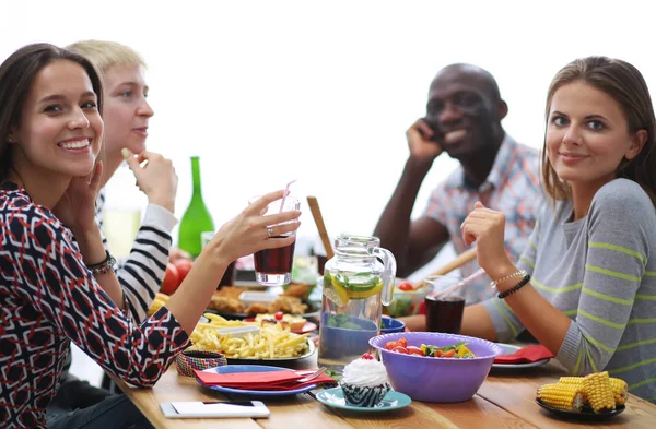 Ahşap masada otururken birlikte yemek yiyen bir grup insanın üst düzey görüntüsü. Masada yemek var. İnsanlar fast food yiyor.. — Stok fotoğraf